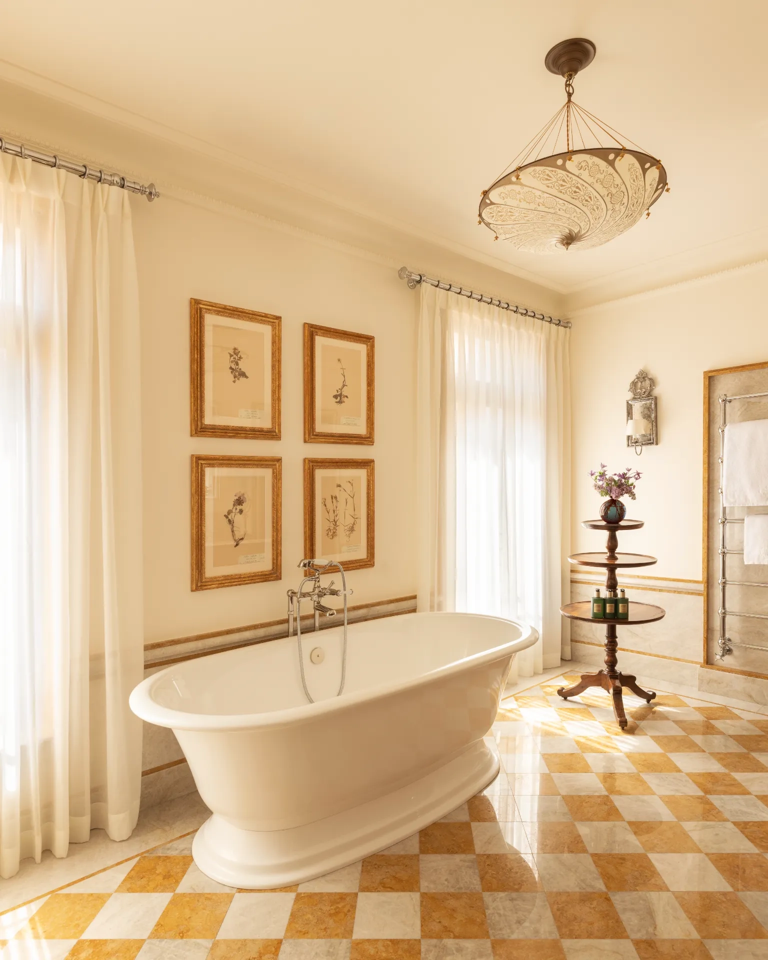 A spacious bathroom in the Airelles Palladio Venezia has yellow and white marble floors