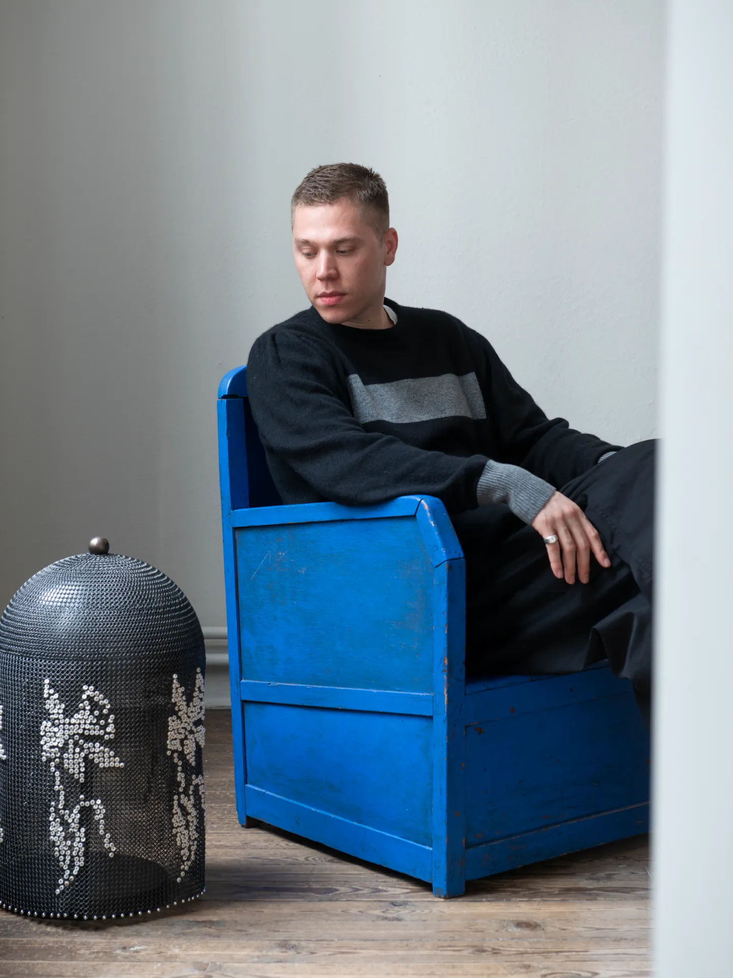 Milan Henderickx of Cour Gallery in Antwerp sitting in a blue armchair